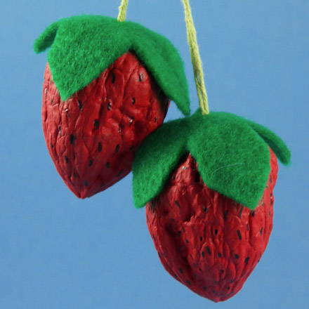 Two walnut strawberries with hangers